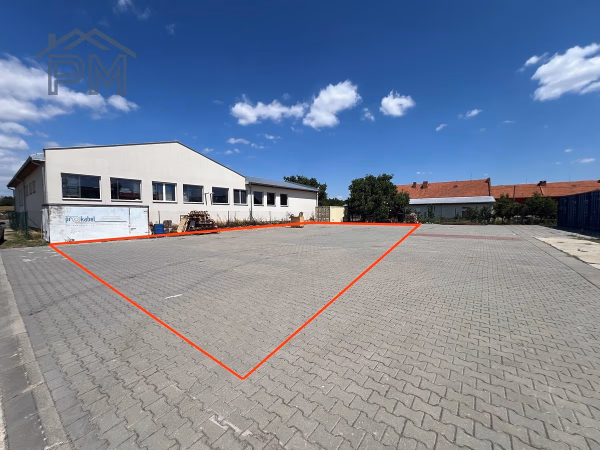 Pronajímaná plocha vyznačená červeně na zámkové dlažbě vedle haly